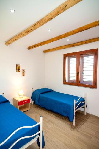 a bedroom with two beds and a window at Residence Tanaunella in Budoni