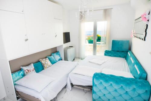 2 łóżka w pokoju z niebieskimi krzesłami w obiekcie Sea view luxury studio apartment w Makarskiej