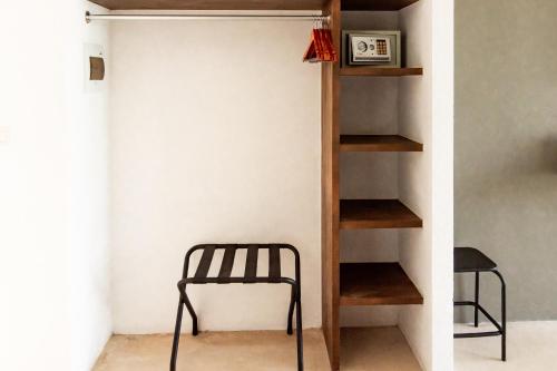 a chair sits in a room with a shelf at Hotel 52 Playa del Carmen in Playa del Carmen