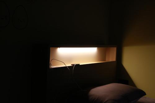 a light in a dark room with a bed at Daegwanryeong Egg Guesthouse in Pyeongchang 