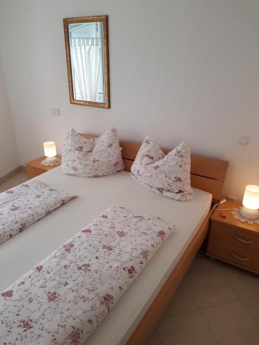 a bedroom with two beds and a mirror on the wall at Guest House Mare e Monti in Rabac