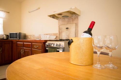 a bottle of wine sitting on a table with two wine glasses at Connie's Comfort Suites in Saint Johnʼs