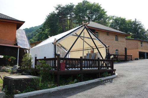 a large tent in a yard next to a building at Daegwanryeong Rodem Tree Pension in Pyeongchang 