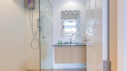 a bathroom with a sink and a shower with a mirror at Anda Beachside Hotel in Karon Beach
