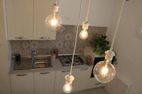 ノートにあるCasa vacanze Cortile Baroccoの天井から数本の照明が掛かるキッチン