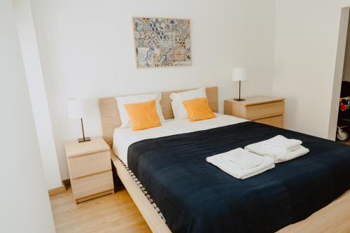 um quarto com uma cama com duas toalhas em A Casa do Jardim à Estrela I em Lisboa
