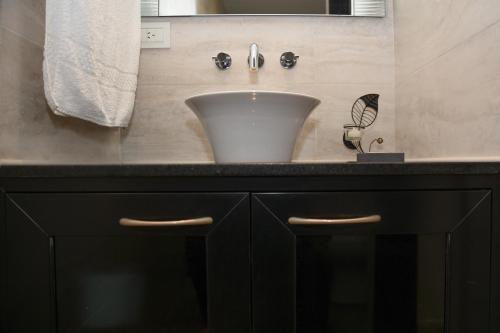a bathroom with a white sink and a black counter at JAK Colón in Colón