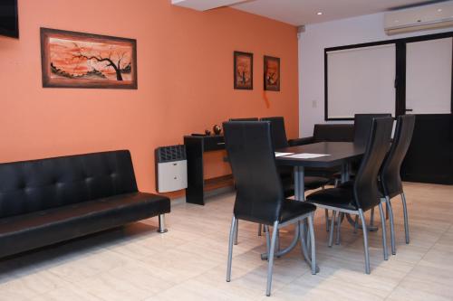 a dining room with a table and black chairs at JAK Colón in Colón