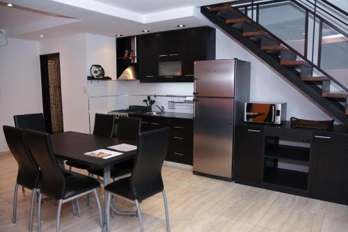 a kitchen with a dining room table and a staircase at JAK Colón in Colón