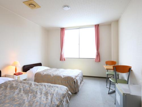 Ένα ή περισσότερα κρεβάτια σε δωμάτιο στο Hotel Silk Inn Madarao