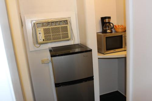 a small kitchen with a microwave and a refrigerator at Wheatland Motel in Vulcan