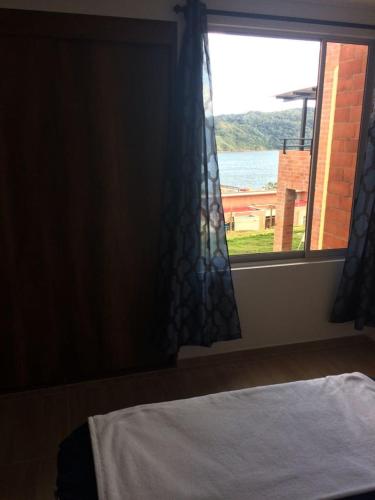 a bedroom with a window with a view of the water at Calima Darien in Calima