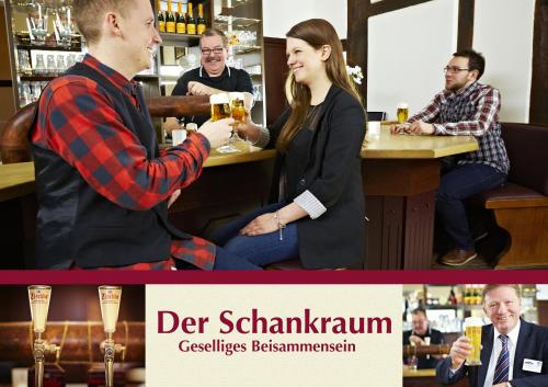 un grupo de personas sentadas en un bar bebiendo cerveza en Hotel Altes Gasthaus Schröer, en Westerkappeln