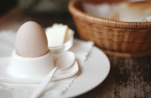 a egg sitting on a plate next to a basket at JinLing Hotel SanFangXiang in Jiangyin