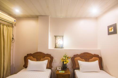 two beds in a room with twoermottermottermott at A&A Plaza Hotel in Puerto Princesa City
