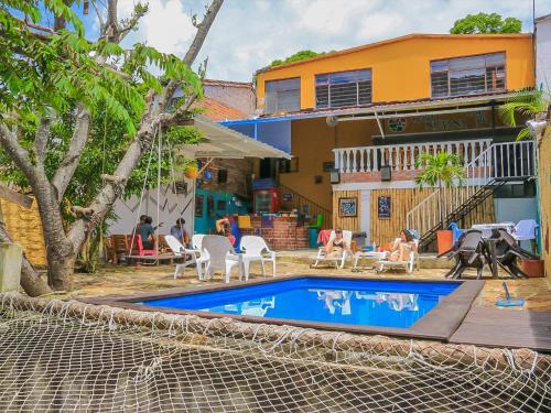 a house with a swimming pool in front of a house at Hostel Nirvana San Gil in San Gil
