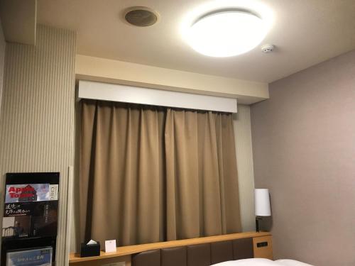 a room with a bed and a window with a curtain at APA Hotel Tokyo Itabashi Ekimae in Tokyo