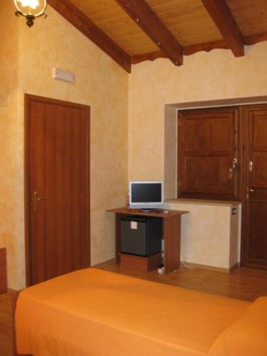 a bedroom with a bed and a desk with a computer on it at B&B COLLE DI CONDRO in Serrastretta