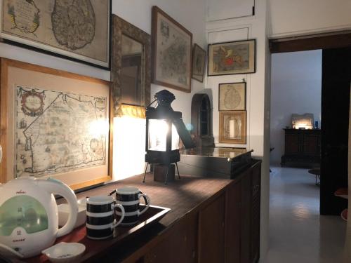 ein Zimmer mit einem Tisch mit einer Lampe und einigen Tassen in der Unterkunft Geoffrey Bawa's Home Number 11 in Colombo