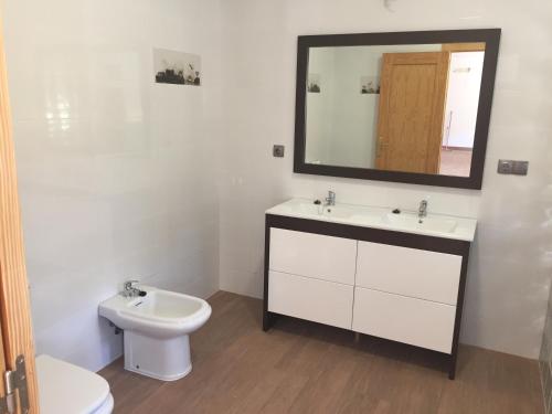 a bathroom with a sink and a toilet and a mirror at La Belleza de Rodalquilar in Rodalquilar