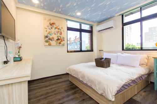 a bedroom with a bed with white sheets and windows at Meizhou Hot Spring Hotel溫泉商旅 in Jiaoxi