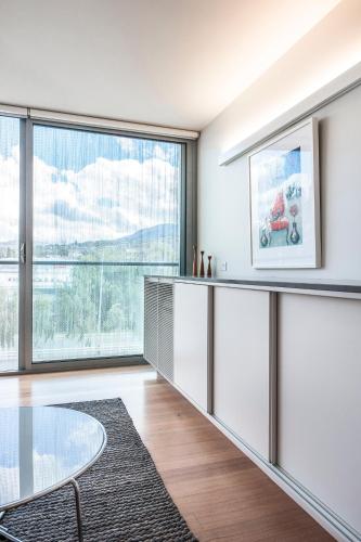 a living room with a glass table and a large window at Quarry House Luxury Retreat in Hobart