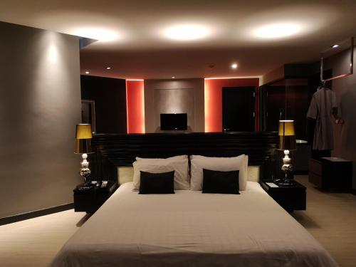 a bedroom with a large bed with two lamps at TSix5 Quarter in Pattaya North
