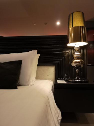 a bedroom with a bed and a lamp on a night stand at TSix5 Quarter in Pattaya North