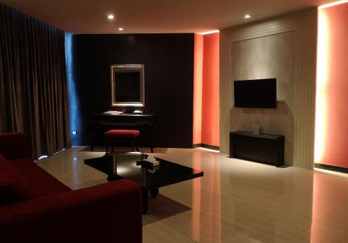 a living room with a red chair and a piano at TSix5 Quarter in Pattaya North