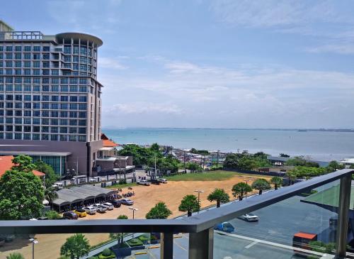 a view of a building and the ocean from a balcony at TSix5 Quarter in Pattaya North