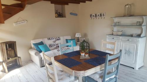 a dining room with a table and a couch at Douceur du D-Day sites historiques du Débarquement in Englesqueville-la-Percée