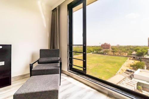 a room with a chair and a large window at The Saneer Jaipur in Jaipur