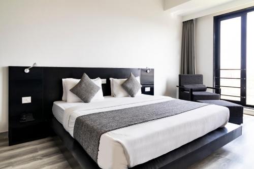 a bedroom with a large bed and a chair at The Saneer Jaipur in Jaipur