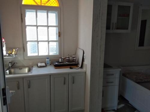 波利克罗诺Maria's beach house的白色的厨房设有水槽和窗户