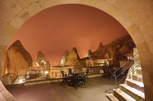 an archway in a cave with tables and chairs at Vezir Cave Suites in Goreme