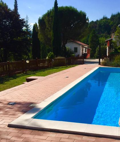 a blue swimming pool in a yard with a fence at Agriturismo Pratofranco in Pontremoli