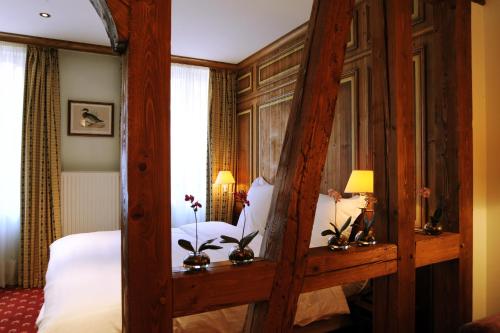 a bedroom with a bed with a wooden frame at Hôtel de l'Europe by HappyCulture in Strasbourg