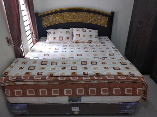 a bed in a bedroom with a bed frame at Narahma Homestay in Bukittinggi