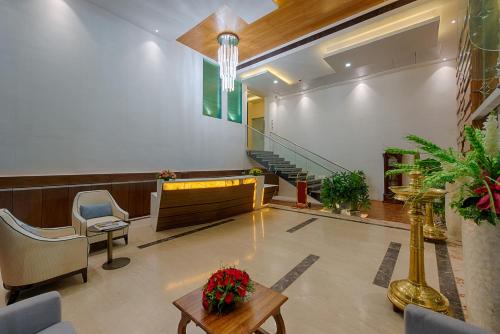 a lobby with a waiting room with a table and chairs at Hotel Lance International in Nāgercoil