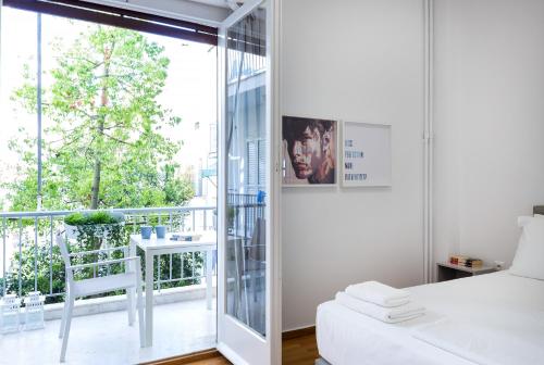 アテネにあるLikavittos Apartmentsのベッドルーム(白いベッド1台、バルコニー付)