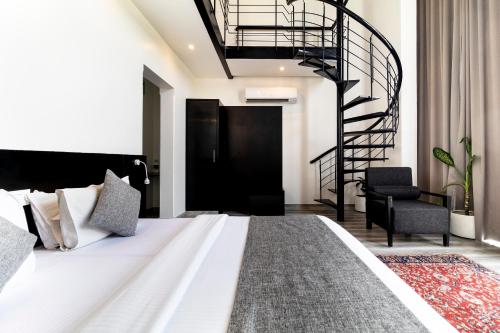 a bedroom with a large bed and a spiral staircase at The Saneer Jaipur in Jaipur
