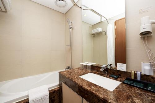 a bathroom with a sink and a bath tub at Migliore Hotel Seoul Myeongdong in Seoul