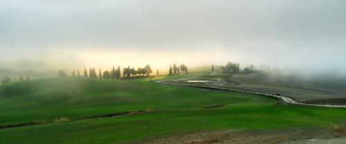 a misty golf course on a hill in the fog at RELAIS VAL D'ORCIA in Pienza