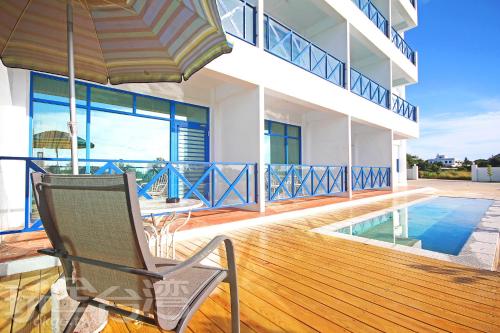 金沙鎮的住宿－金門海灣Villa會館 ，阳台配有椅子和遮阳伞。