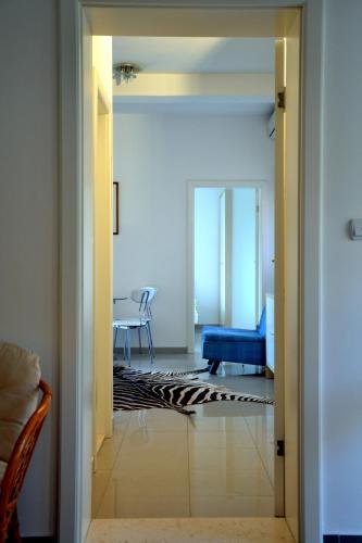 a hallway leading to a living room with a blue couch at Montesun Residence in Herceg-Novi