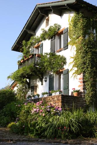 a white house with flowers in front of it at Maison Aretxola in Sare