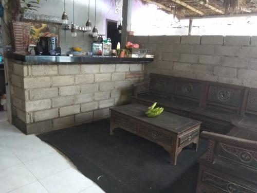 a room with two benches and a table with bananas on it at Ijen Farmer Homestay in Banyuwangi