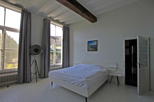 una camera da letto bianca con un letto e una finestra di Bed & breakfast in monumental house maastricht centre a Maastricht