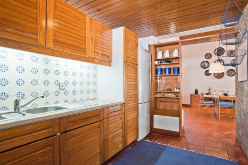a kitchen with wooden cabinets and a sink at BmyGuest - Sesimbra Country Villa in Sesimbra