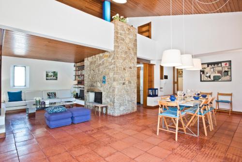 a living room with a table and a stone fireplace at BmyGuest - Sesimbra Country Villa in Sesimbra